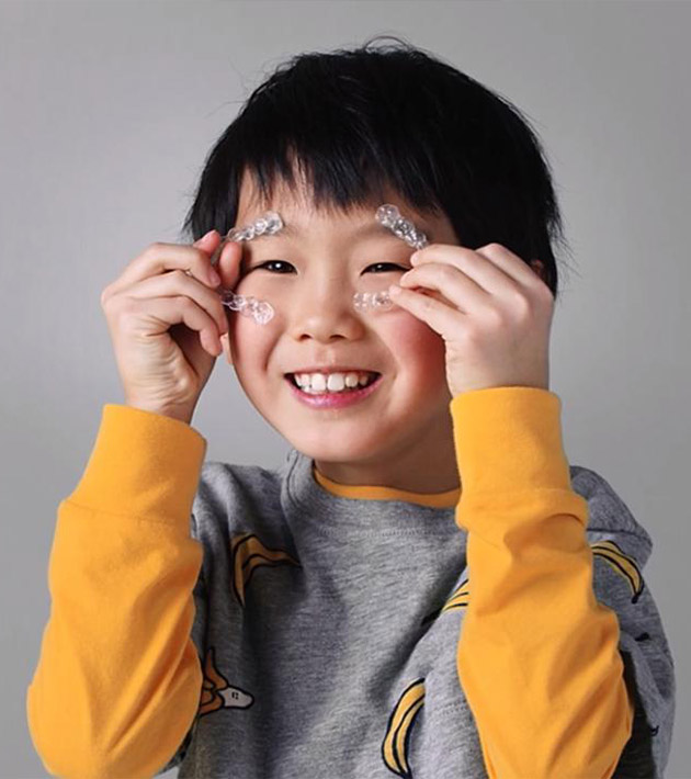 kid holding invisalign treatment trays